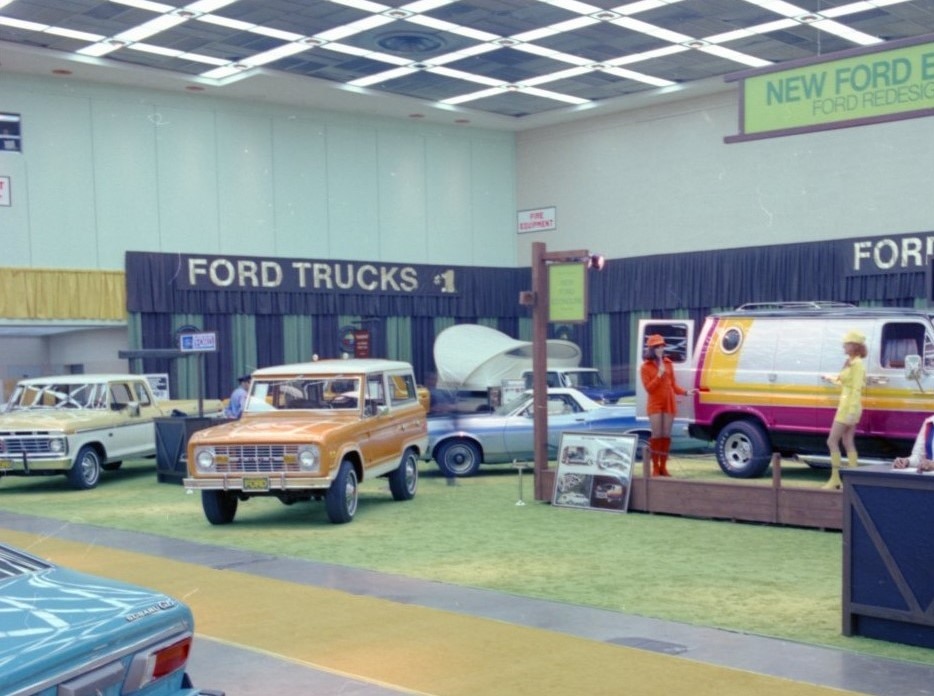 An old color photo of Ford vehicles on a show floor